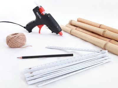 Mit nur wenigen Materialien zur kreativen Wandbild-Idee. Materialien für die Leinwände an Bambus: Heißklebepistole, Stift, Schnur, Bambusrohre und Leinwände.